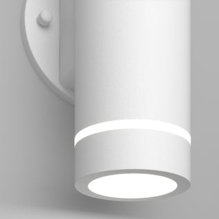 A close-up of the Artika C7 indoor-outdoor LED wall light 3 CCT, a modern cylindrical white fixture featuring a glowing ring near the top and a bright circular bottom light, mounted on a round wall plate.