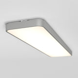 A rectangular, modern ceiling light fixture with rounded edges and a smooth, white surface emitting a soft, even glow against a plain white ceiling.