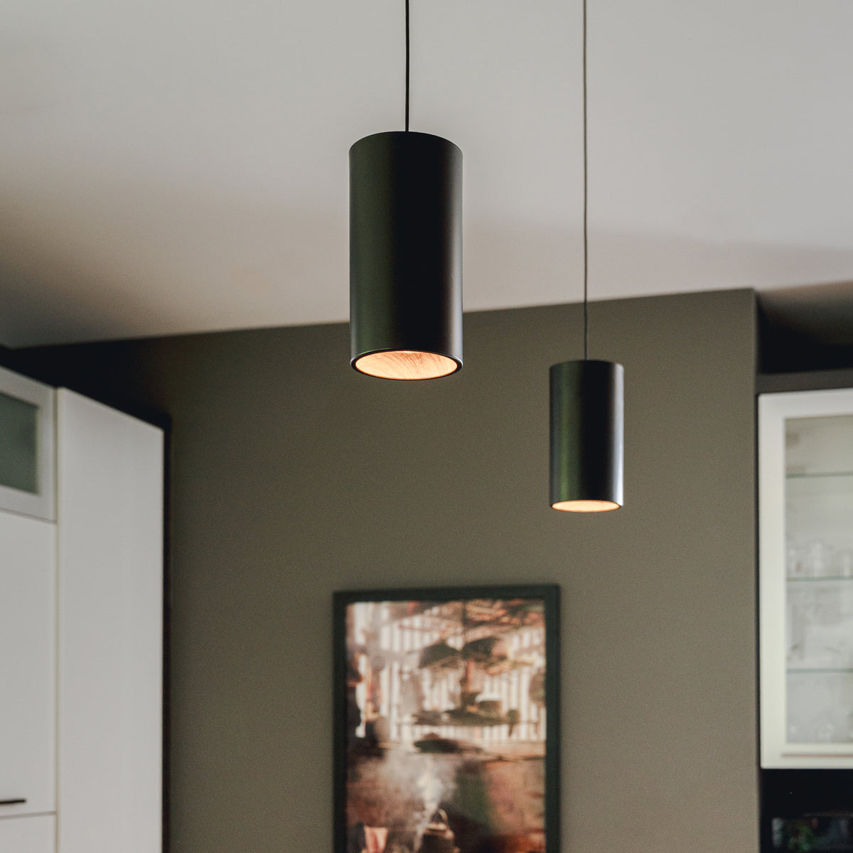 Two Artika Alton mini LED pendant lights (5 CCT) hang in a kitchen with dark walls and white cabinetry.