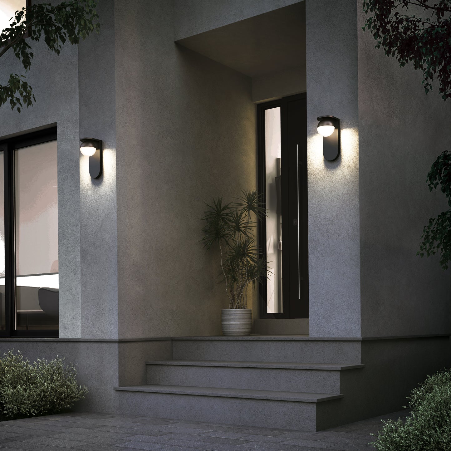 A modern house entrance at dusk features gray walls lit by two Artika Bloom indoor-outdoor LED wall lights (3 CCT), with a potted plant beside the door and steps leading up to the front entrance.