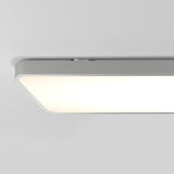 A close-up view of a modern rectangular ceiling light fixture with a soft, diffused glow, mounted on a smooth white ceiling.