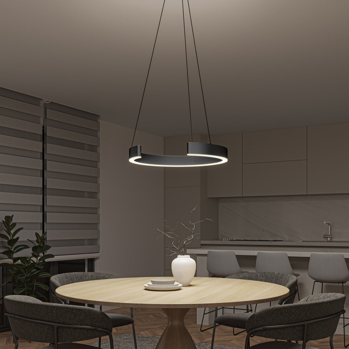 A modern kitchen and dining area with a round wooden table, four gray chairs, a white vase with twigs, and the Artika Vance modern LED pendant light 3 CCT hanging above. Sleek cabinets, a countertop, and a plant complete the background.