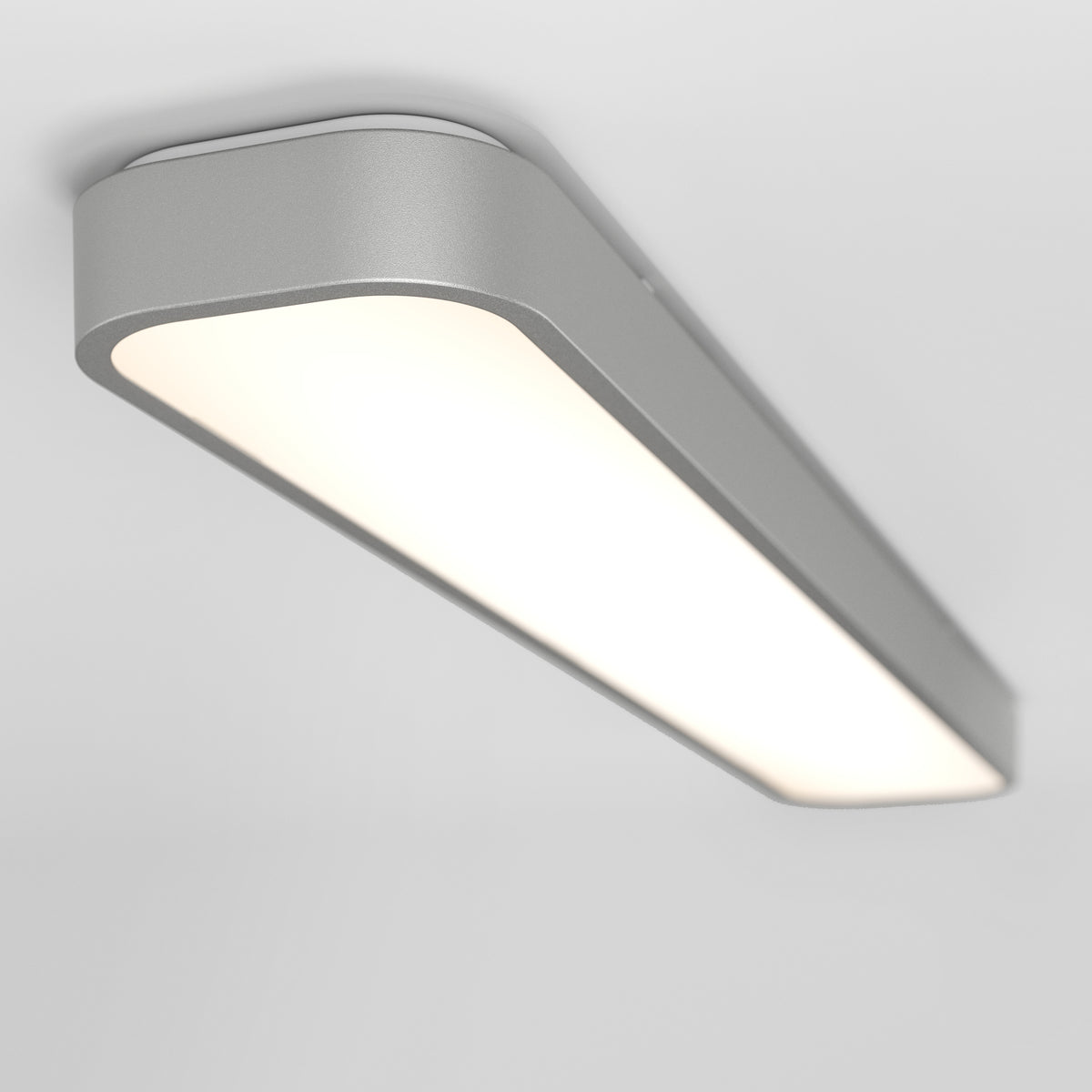 The Artika Europa 36 LED flush mount light features a sleek rectangular design with a smooth silver frame and frosted surface, mounted on a white ceiling. Includes remote control for easy lighting adjustments.