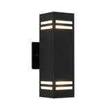 A modern black rectangular wall sconce with horizontal slits on the top and bottom, emitting warm light through the openings, mounted on a plain white background.