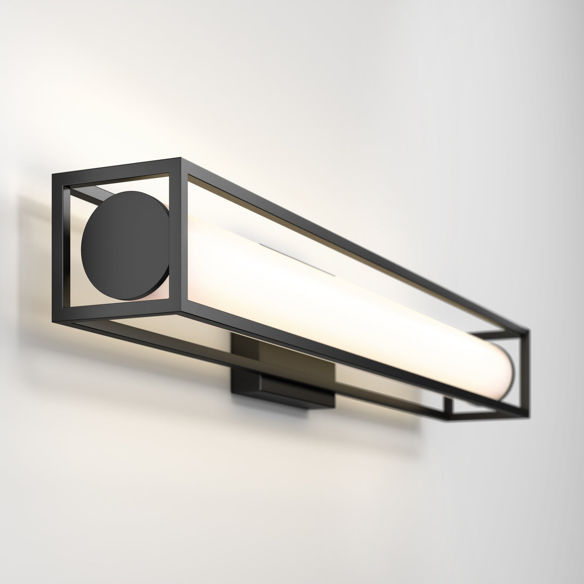 A modern wall sconce with a rectangular black metal frame and a cylindrical white light fixture, mounted on a smooth, light-colored wall.
