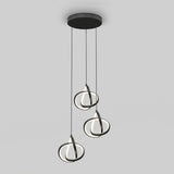 A modern ceiling pendant light fixture with three hanging LED rings in black, each suspended at different heights from a round black base against a plain grey background.