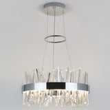 Modern chandelier with a circular chrome frame, featuring multiple clear, jagged crystal rods hanging down, suspended from the ceiling by three thin cables against a plain light background.