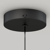 A close-up view of a modern, round black ceiling light canopy with a cord hanging down from its center, set against a plain white ceiling.