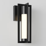 A modern black outdoor wall sconce with a rectangular frame and a cylindrical frosted light in the center, mounted on a plain white wall.