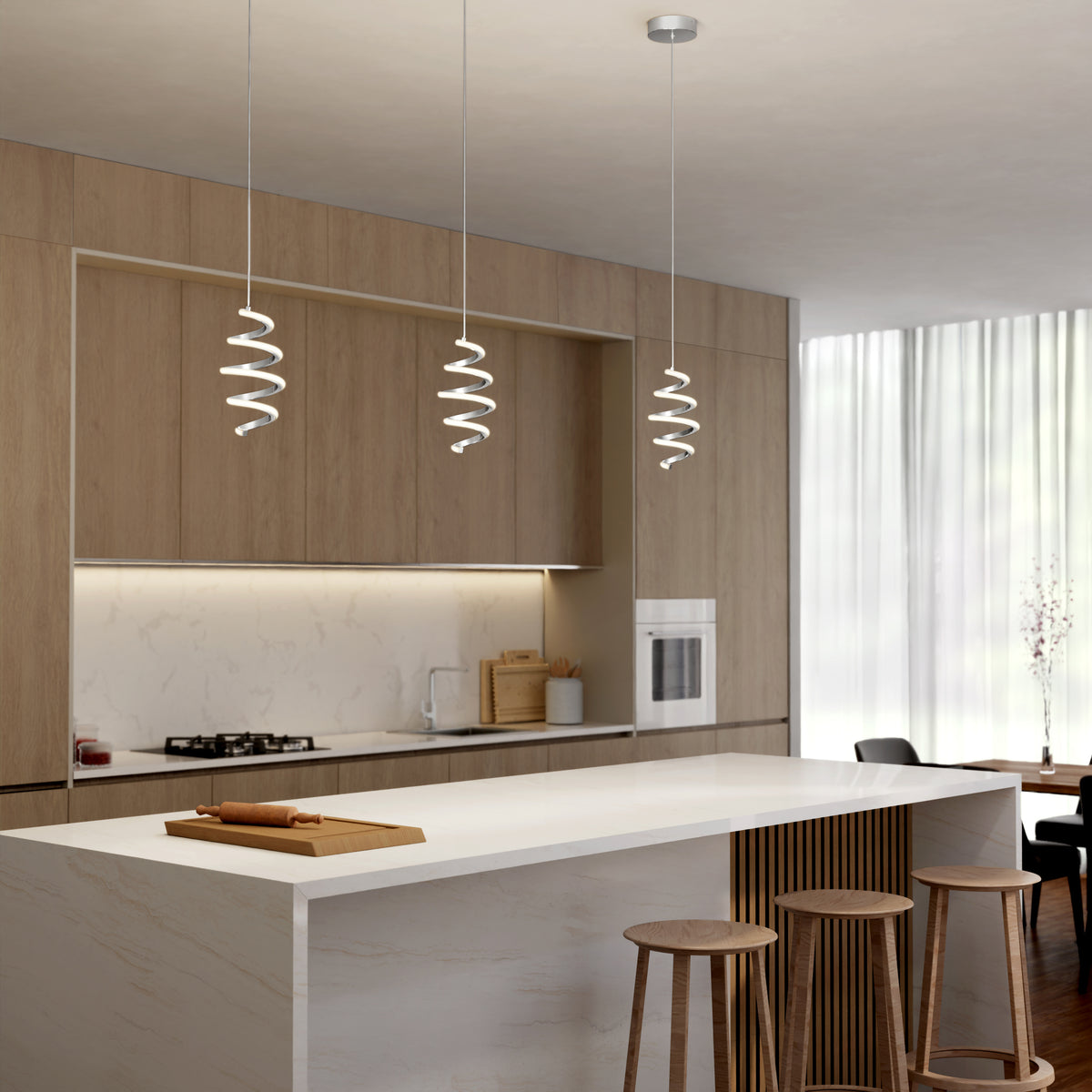 A modern kitchen features light wood cabinets, a marble island with three wooden stools, built-in appliances, sheer curtains for natural light, and Artika's Chorus 1-light LED pendant 5 CCT for stylish illumination.