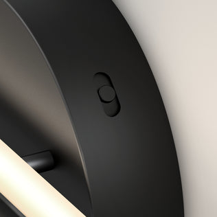 Close-up of the Artika Cisco 27-in Integrated LED 5-CCT Vanity Light Bar in black, featuring a circular side push button and adjustable color temperature, shown with its sleek, minimalist design on a light-colored bathroom wall.