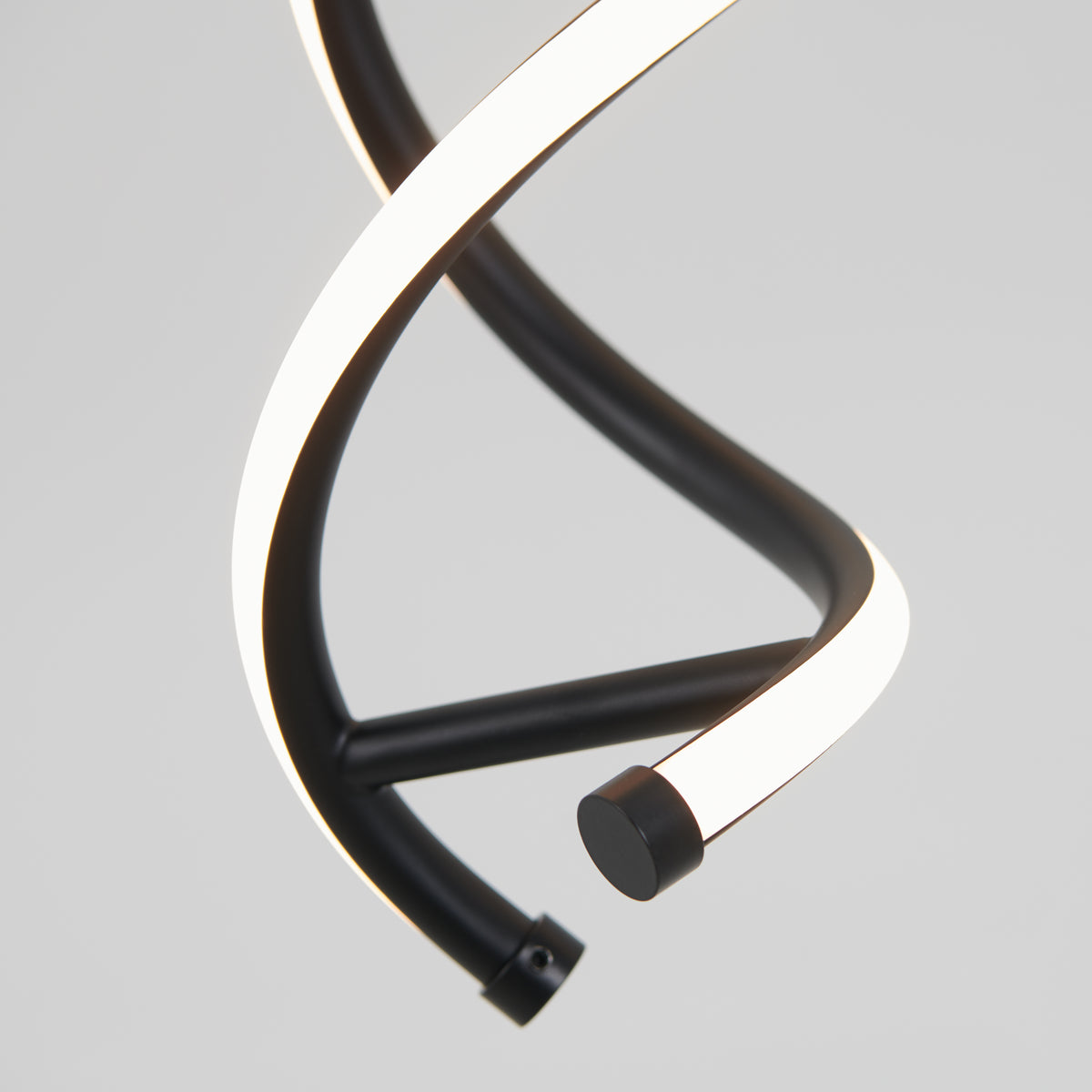 A close-up of a modern, black and white LED pendant light with a spiral, twisting design against a plain light gray background.