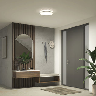 Modern entryway with bench, oval mirror, plants, and a gray door under the Artika Hemisphere 15″ LED Flush Mount Ceiling Light (5 CCT).