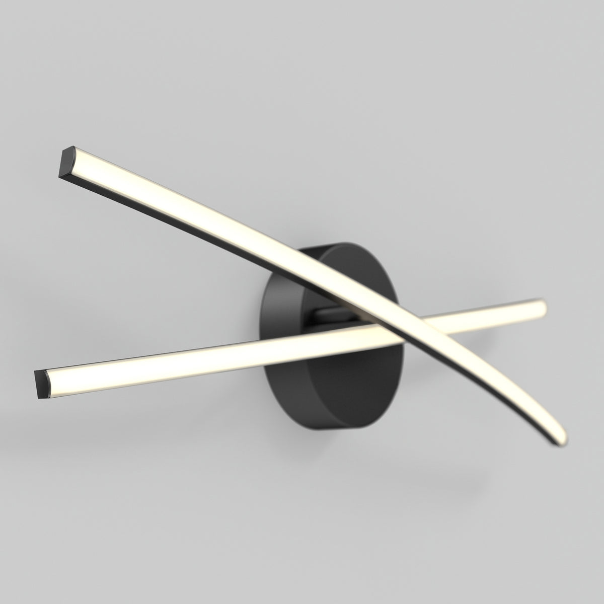 A modern wall light with two curved, glowing LED bars crossing in front of a round black base, mounted on a plain light gray wall.