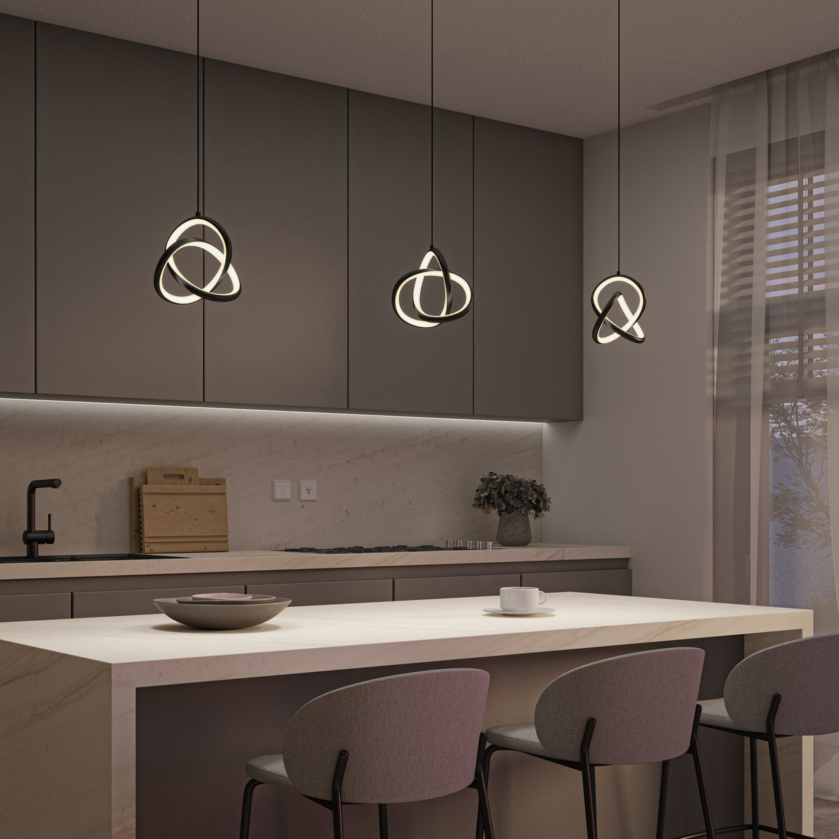 Modern kitchen with gray cabinets, a light marble island with three gray barstools, unique geometric pendant lights, and soft natural light coming through sheer curtains. Minimalistic decor includes a bowl, cup, and a small plant.
