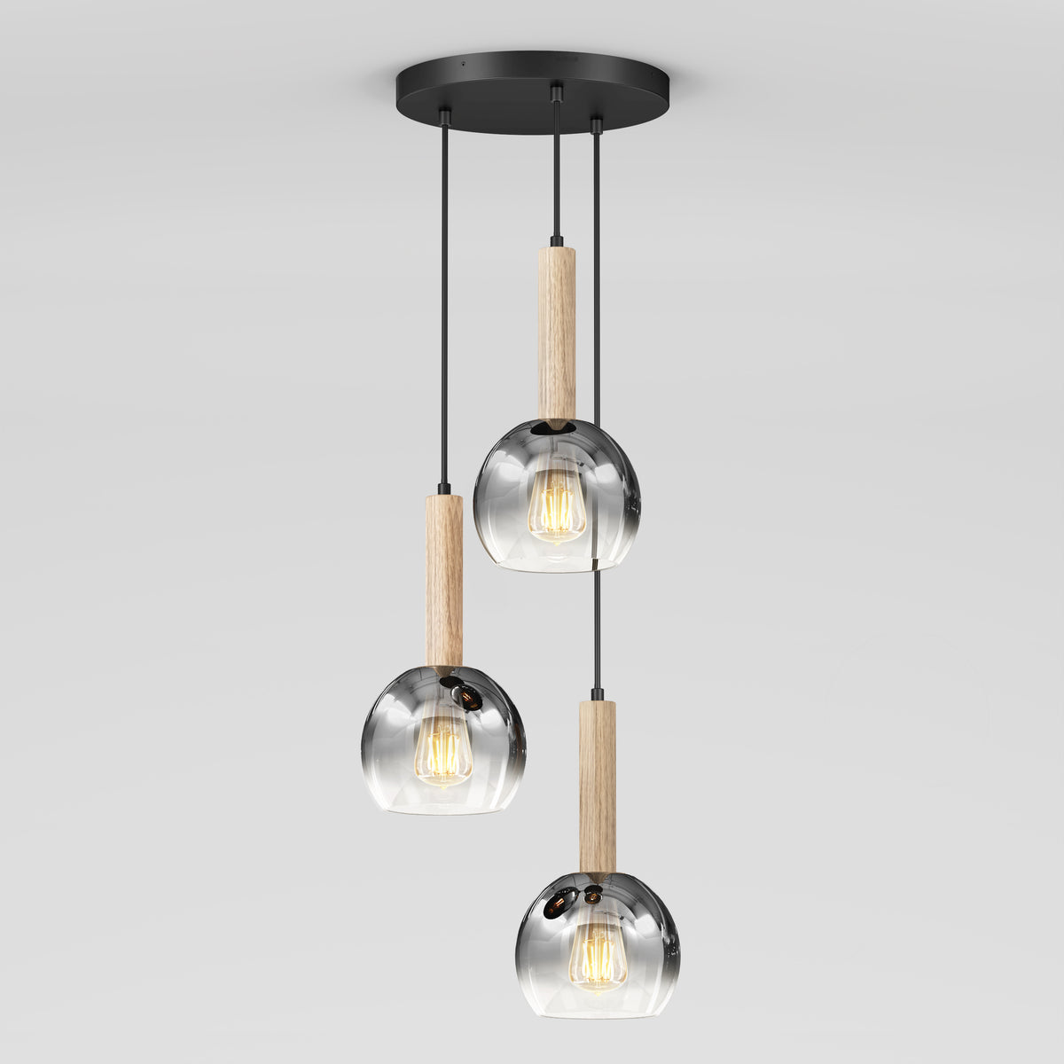 The Ardel Spiral 3-Light Pendant by Artika features clear glass shades and wooden accents, suspended at varying lengths from a round black mount, shown without bulbs against a plain white background.
