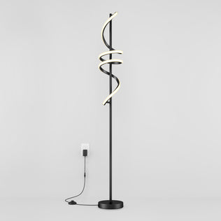 The Artika Coda modern LED floor lamp 5CCT features a black stand with three spiral LED light tubes, dimmable for customizable ambiance, standing against a white wall and plugged into a wall outlet.