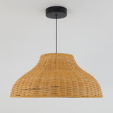 A wicker pendant light with a wide, woven rattan lampshade hangs from the ceiling by a black cord and circular ceiling mount against a plain white background.