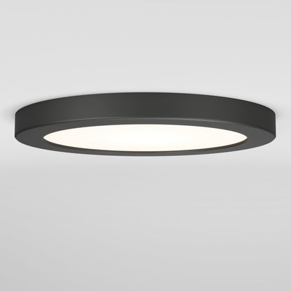 The Artika Europa Disk 7 in. LED modern flush mount light features a flat, round black design and offers 3 CCT options, emitting bright white light against a plain white ceiling and wall.