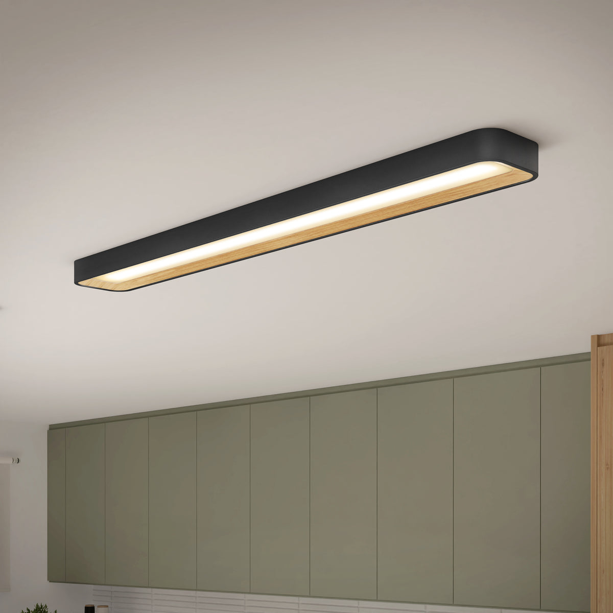 An Artika Alton 48 in. LED flush mount light with a black and wood finish is installed above olive green kitchen cabinets, softly illuminating the space below.