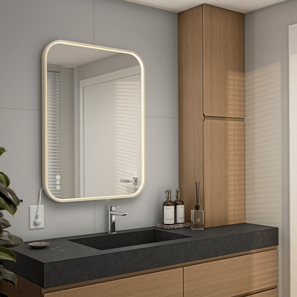 Modern bathroom with the Artika Royce Dimmable LED Mirror (3 CCT, horizontal/vertical mount) above a black sink and wooden cabinets. Two bottles and a reed diffuser sit on the counter. The mirror reflects a door and window.