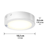 Round white LED puck light with a glowing center, shown with dimensions: 10.2 cm (4 in) in diameter and 2.6 cm (1.02 in) in height.
