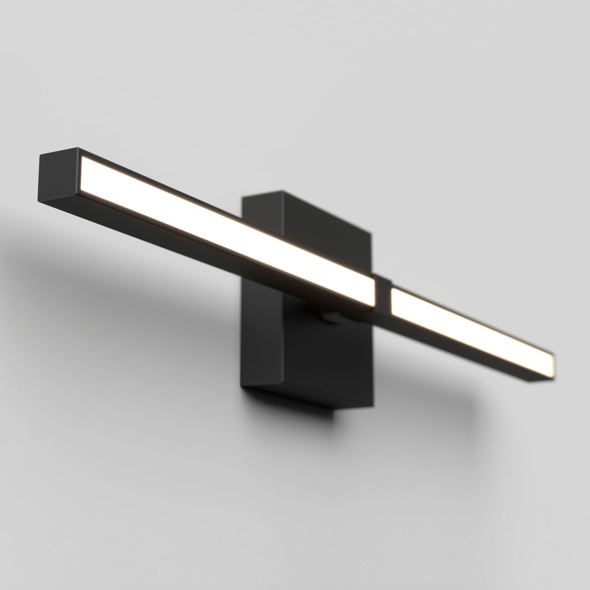 A modern black wall-mounted LED light fixture with a rectangular back plate and a long horizontal bar emitting bright white light, set against a plain light-colored wall.