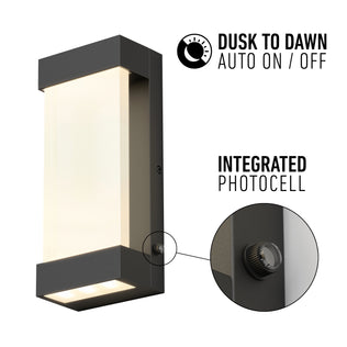 Artika Glacier indoor-outdoor LED wall light shown with a close-up of its integrated photocell. Text: “Dusk to Dawn Auto On/Off” and “Integrated Photocell.” Features a modern rectangular design with dark frame and lit panel.