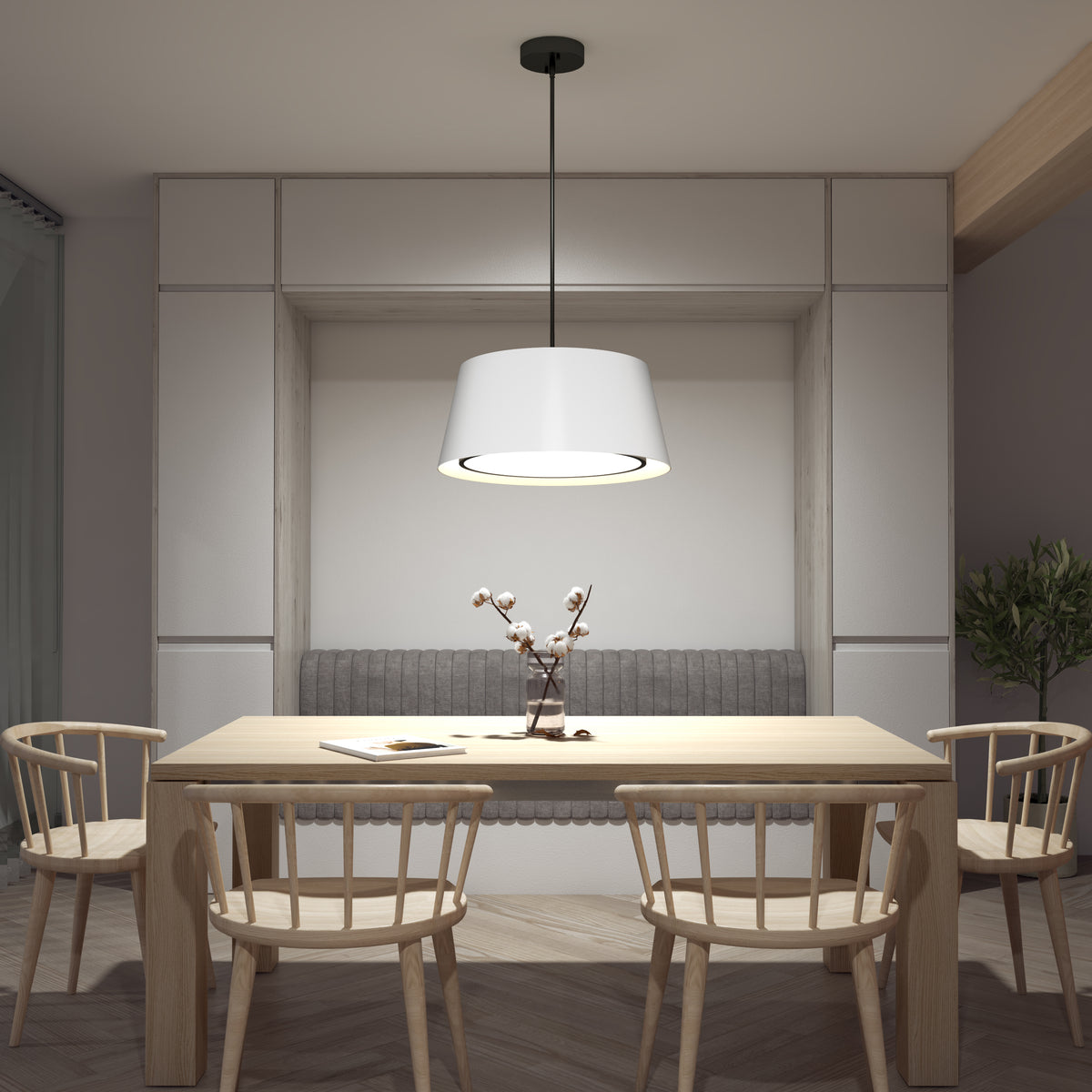 A modern dining area with a wooden table, four matching chairs, a grey cushioned bench, a white pendant light above, and a small vase with branches as the centerpiece. Neutral tones create a minimalist atmosphere.