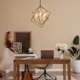 A modern home office with a wooden desk, laptop, coffee cup, vase of white flowers, and a tan chair. A blurred person walks by abstract art on the wall. A geometric pendant light hangs from the ceiling.