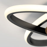 Close-up of a modern ceiling light fixture with intertwined black and white illuminated rings, set against a plain light-colored background.