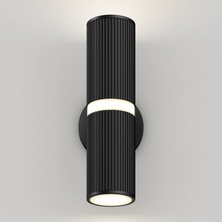 The Groove LED indoor-outdoor wall light by Artika features a modern black cylindrical design with vertical ridges and a round base, casting light from both ends to create a soft glow on any plain white wall.