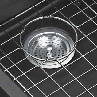 Close-up of the Artika Baycrest 33 in. Double Bowl Kitchen Sink in black, featuring a strainer and protective wire rack above the drain.
