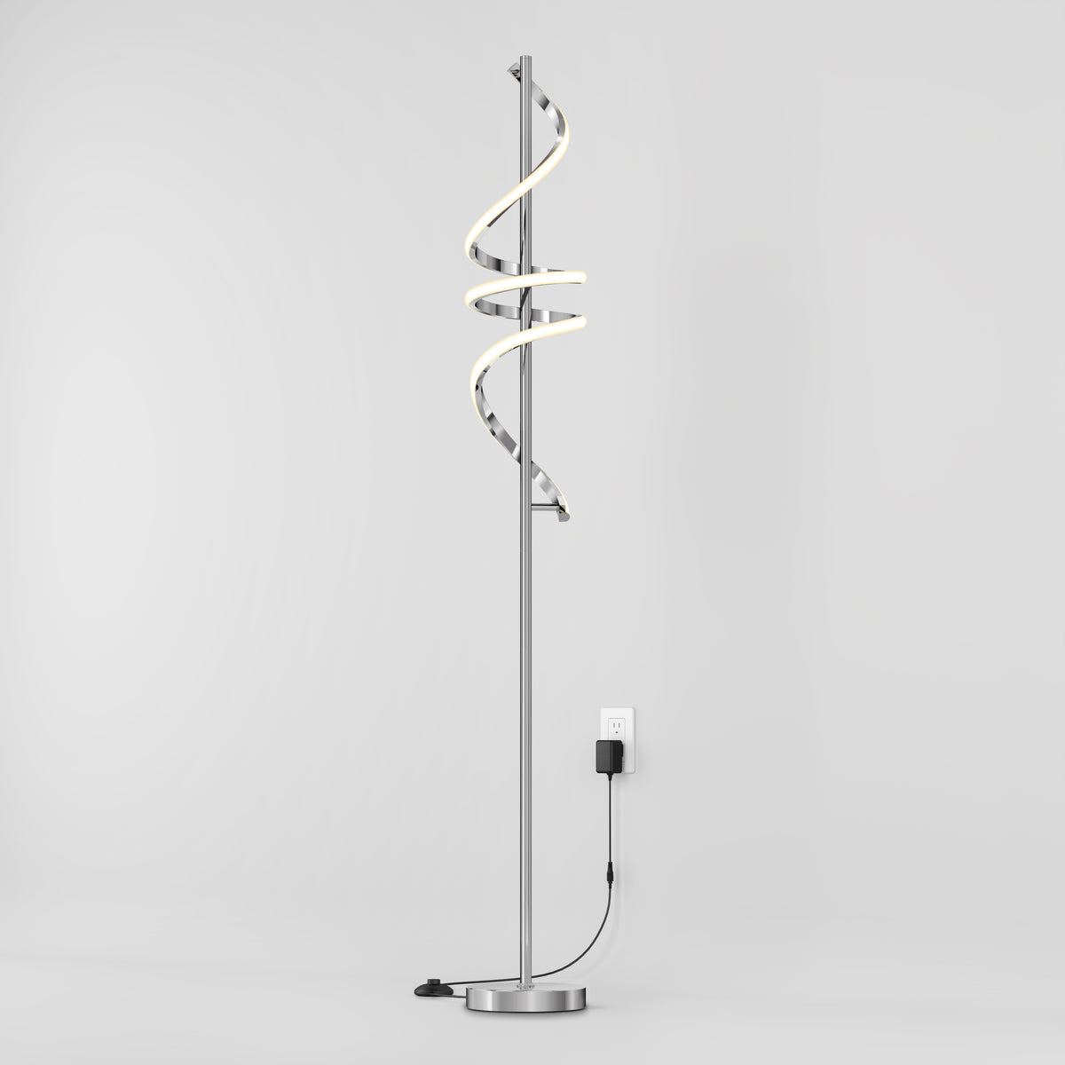 The Artika Coda modern LED floor lamp 5CCT features a spiral LED design, dimmable lighting, and a round metallic base. Its minimalist arched style plugs into a wall outlet and is shown against a plain white background.