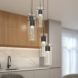 A modern kitchen with wood cabinets, marble backsplash, and five cylindrical pendant lights with bubbles inside, hanging above a white countertop and black sink. Large windows let in natural light.