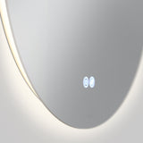 A close-up of a modern round mirror with a soft backlight along the edge. Two illuminated touch buttons are visible on the surface, reflecting a minimalist and sleek design.