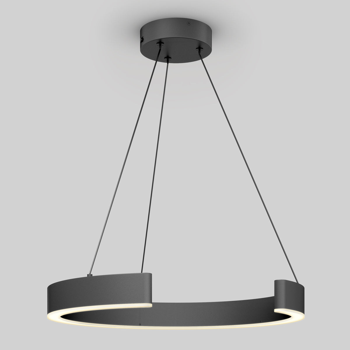 A modern, circular, matte black pendant light fixture is suspended from the ceiling by three thin cables, emitting a soft white light from the inner rim. The background is a plain light gray.