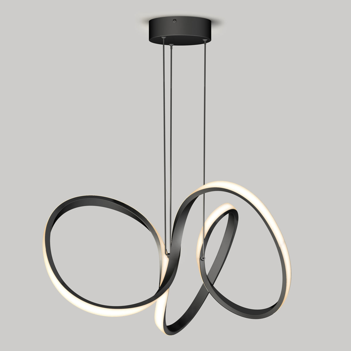 The Artika Swirl LED pendant light features three interlocking black metal loops—two with integrated LED strips—suspended by thin cables from a round black base against a plain gray background.